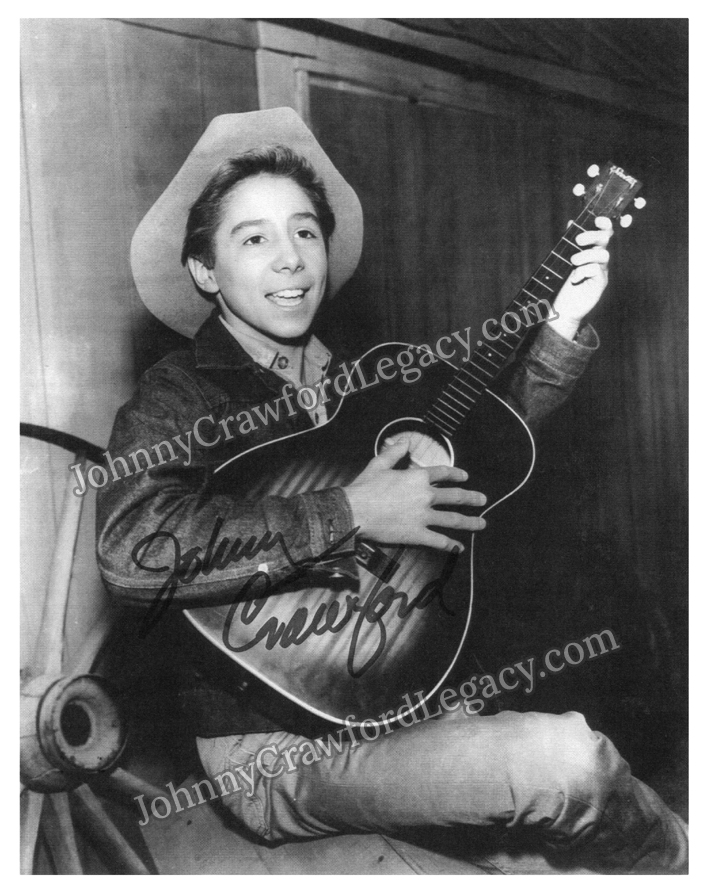 a photo of Johnny Crawford with a guitar and cowboy hat